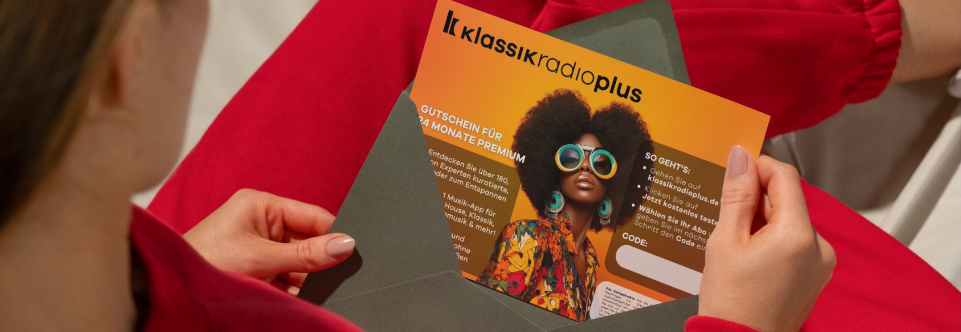 Blick von oben auf eine Frau, die gerade einen Umschlag mit einem Klassik Radio Plus Gutschein öffnet