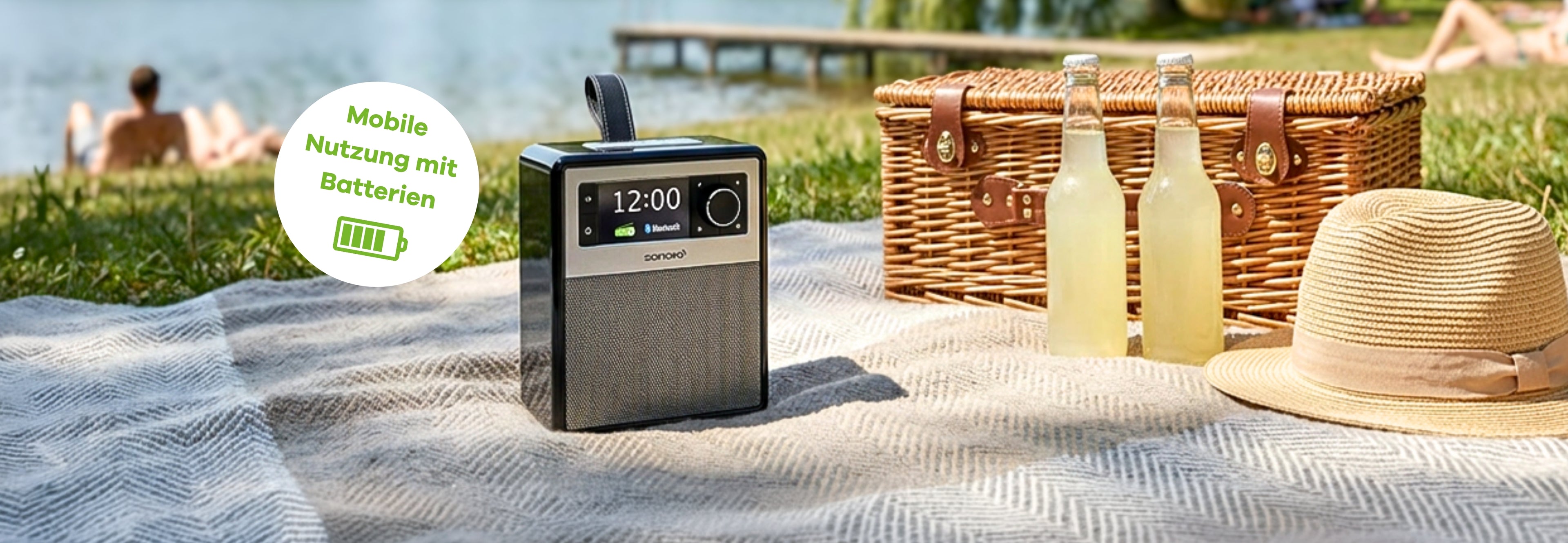 sonoro Easy auf einer Picknickdecke. Daneben ein Picknich-Korb und Limonade