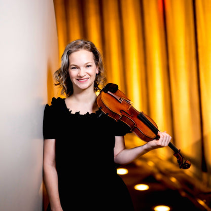 Portrait der Violinistin Hilary Hahn, die eine Violine in einer Hand hält, auf ihrer Schulter gelehnt
