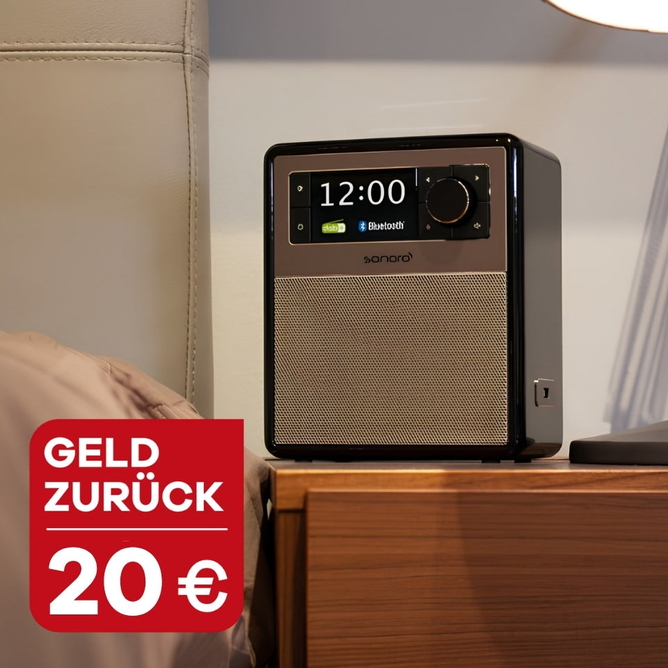 sonoro EASY in Schwarz steht auf einem Beistelltisch aus Holz neben einem Bett im Schlafzimmer