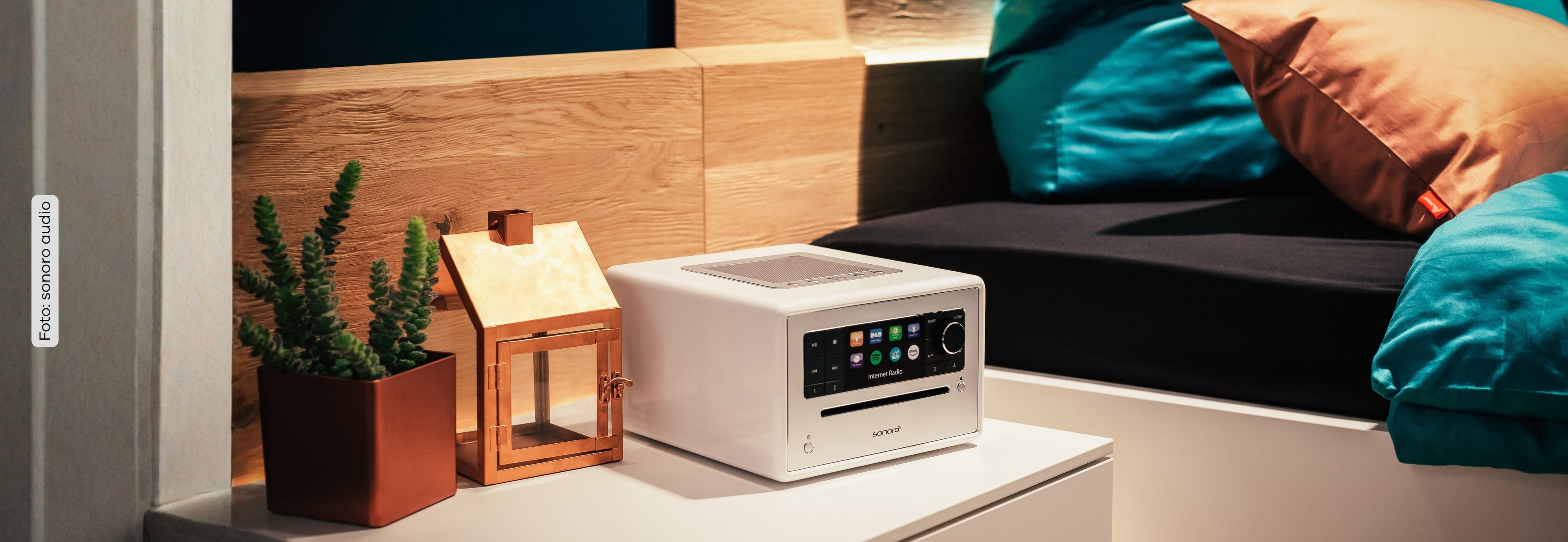 sonoro ELITE auf dem Nachttisch im Schlafzimmer mit Pflanze und Kerzengehäuse